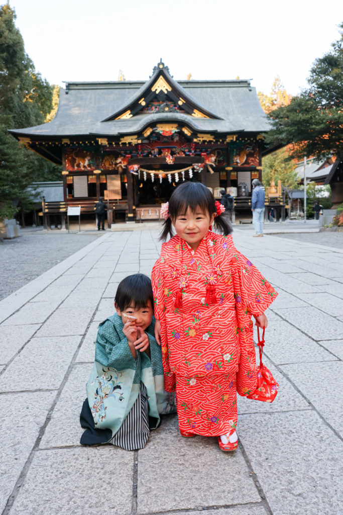 秩父神社本殿前での3歳と5歳の微笑む七五三写真